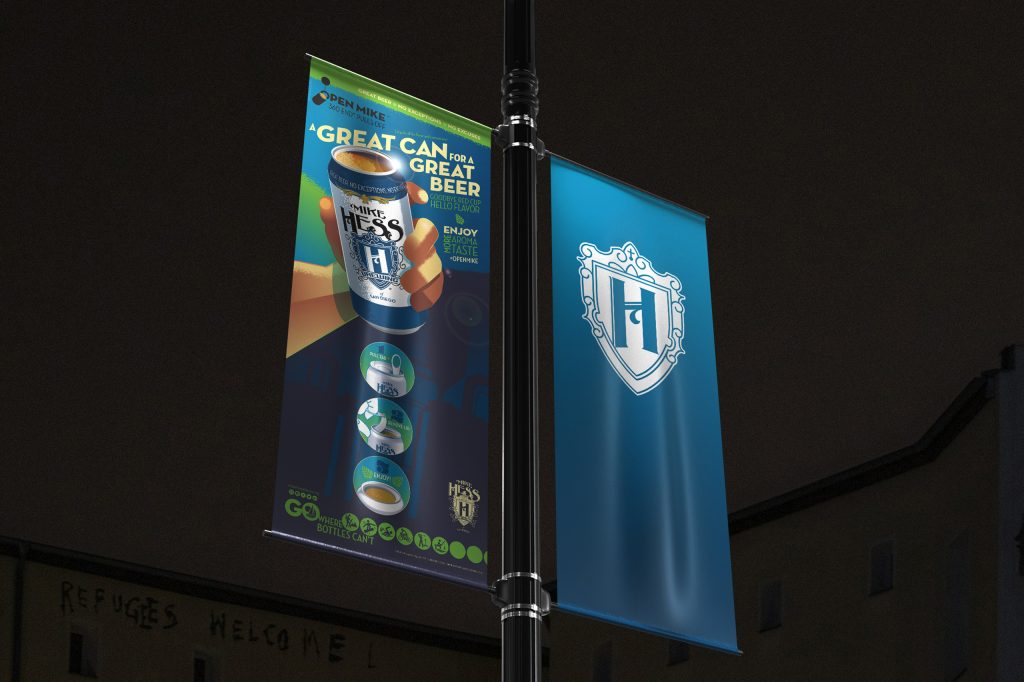 2560x1705-portfolio-open-mike A street light banner with an illustration of a hand holding a beer on one side and a shield with an H on the other.