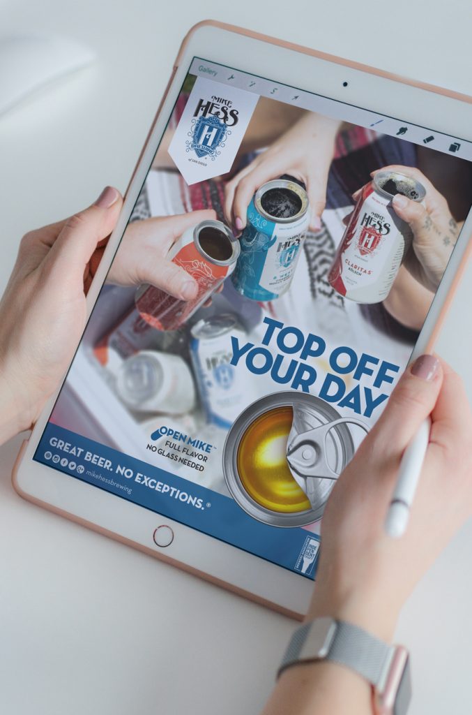 top-off-ad-tablet hands holding a digital tablet that has a Mike Hess Brewing ad on it. The headline says "Top off your day"