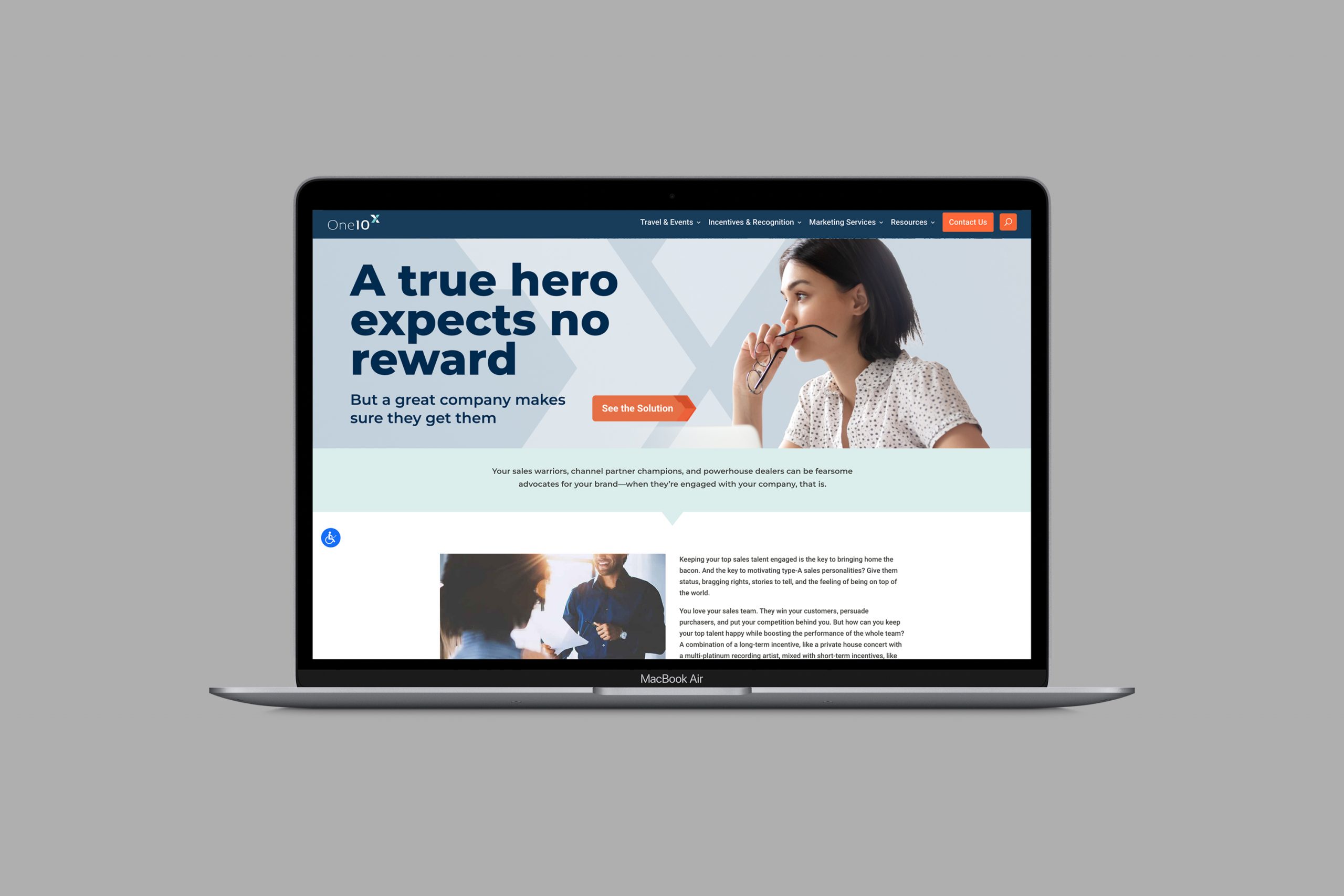 OneX-laptop-landing-page A laptop with a landing page showing a womaon the right looking toward a headline that says "A ture hero expects no reward."